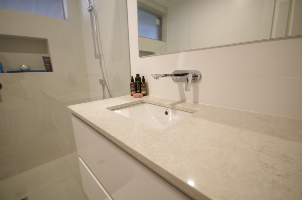 Exempel på ett modernt vit vitt en-suite badrum, med möbel-liknande, vita skåp, en öppen dusch, vit kakel, porslinskakel, vita väggar, klinkergolv i porslin, ett undermonterad handfat, bänkskiva i kvarts, gult golv och med dusch som är öppen