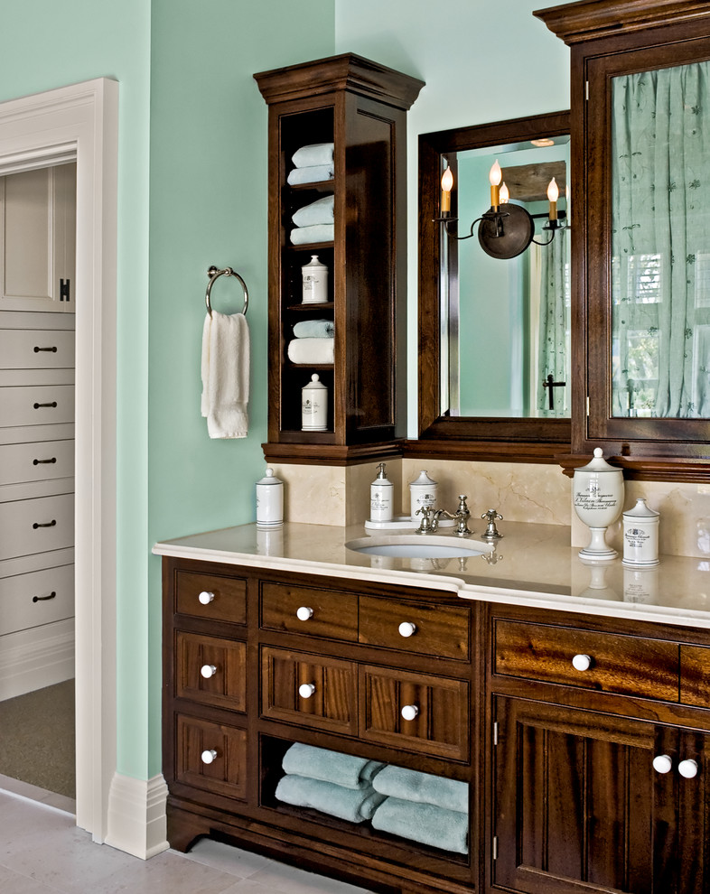 Imagen de cuarto de baño tradicional con lavabo bajoencimera, armarios con paneles lisos, puertas de armario de madera en tonos medios y baldosas y/o azulejos beige