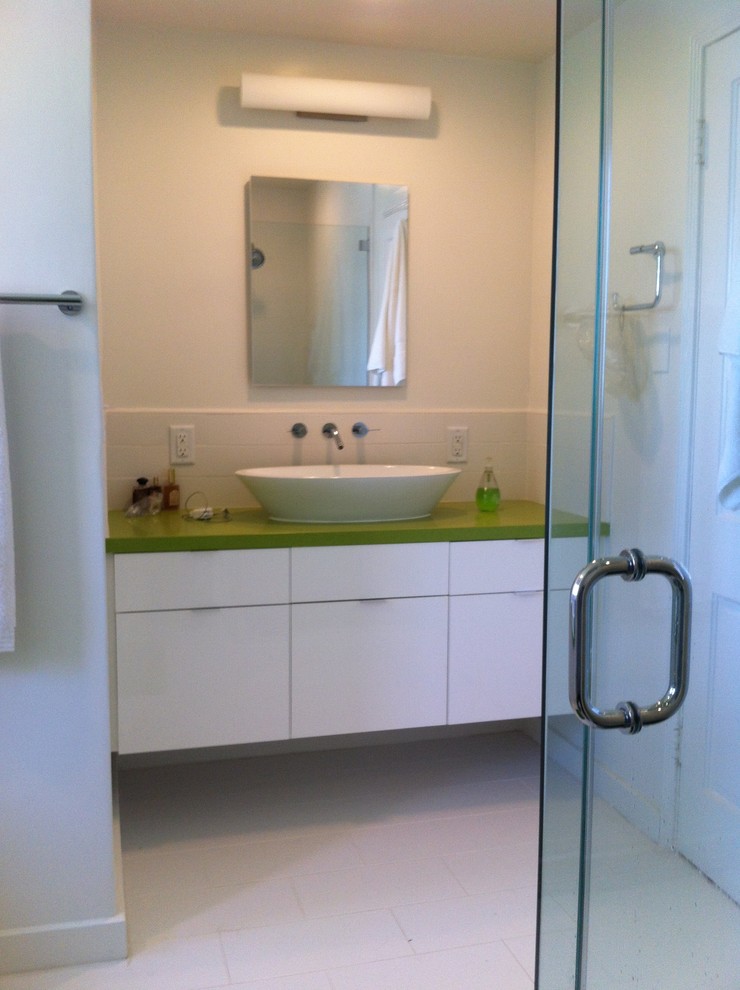 Cette image montre une salle de bain design avec une vasque, un placard à porte plane, des portes de placard blanches, un plan de toilette en quartz modifié, une douche d'angle, WC séparés, un carrelage blanc et des carreaux de céramique.