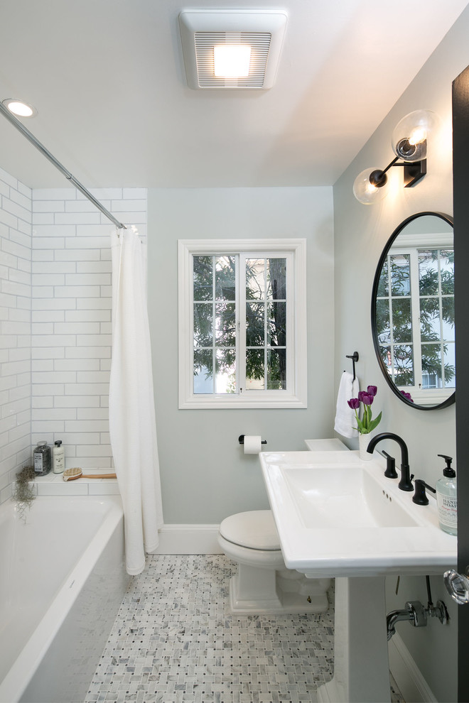 Aménagement d'une petite salle d'eau classique avec une baignoire d'angle, un combiné douche/baignoire, WC séparés, un carrelage blanc, des carreaux de porcelaine, un mur bleu, un sol en carrelage de terre cuite, une vasque, un sol blanc et une cabine de douche avec un rideau.