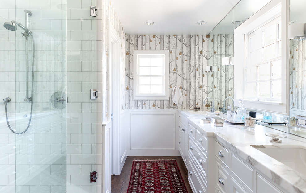Inspiration for a traditional ensuite bathroom in Sacramento with raised-panel cabinets, white cabinets, a corner shower, white tiles, ceramic tiles, multi-coloured walls, dark hardwood flooring, a submerged sink, brown floors, a hinged door and white worktops.