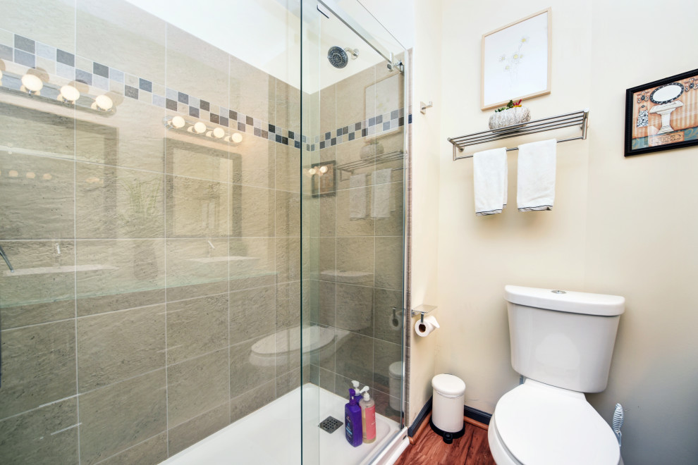 Example of a mid-sized transitional 3/4 gray tile and porcelain tile bathroom design in Other with glass-front cabinets, dark wood cabinets, a two-piece toilet, beige walls, a vessel sink, glass countertops and green countertops