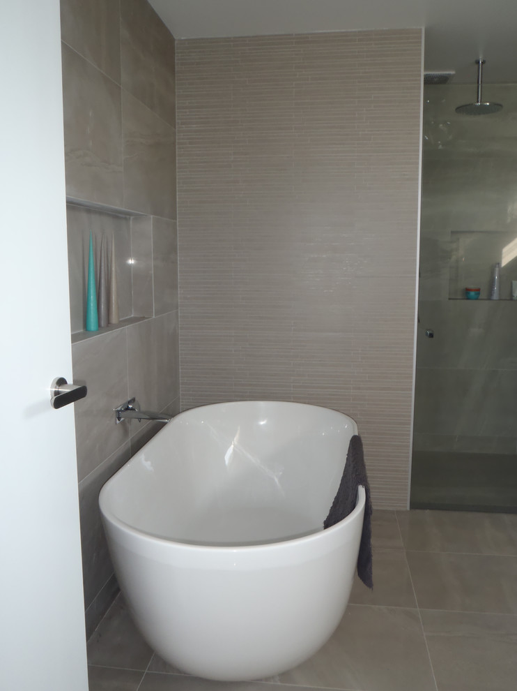 Inspiration för ett mellanstort funkis en-suite badrum, med ett väggmonterat handfat, bänkskiva i kvartsit, ett fristående badkar, en dusch i en alkov, grå kakel, porslinskakel, grå väggar och klinkergolv i porslin