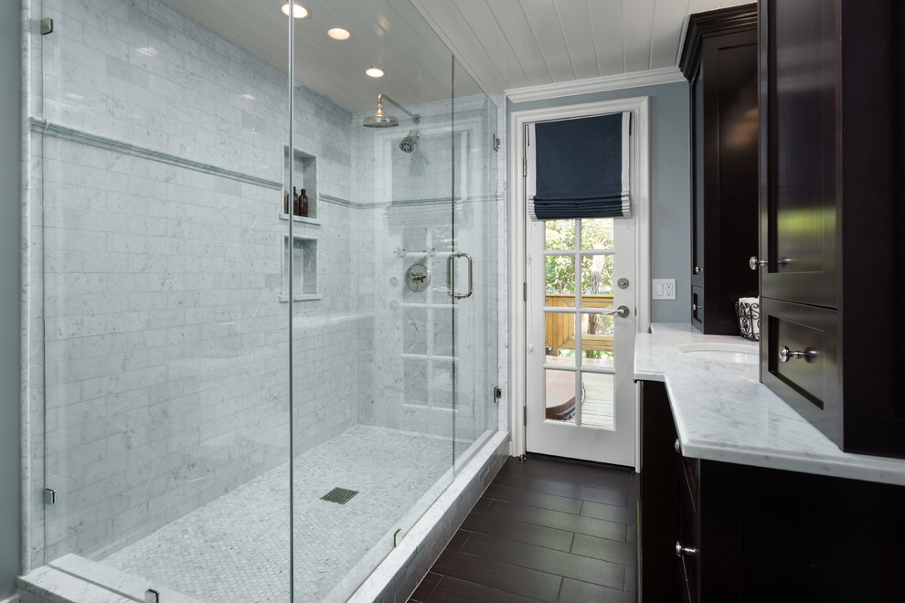 Inspiration för små klassiska badrum med dusch, med luckor med infälld panel, skåp i mörkt trä, marmorbänkskiva, en dubbeldusch, vit kakel, mörkt trägolv, brunt golv, ett undermonterad handfat, dusch med gångjärnsdörr och tunnelbanekakel