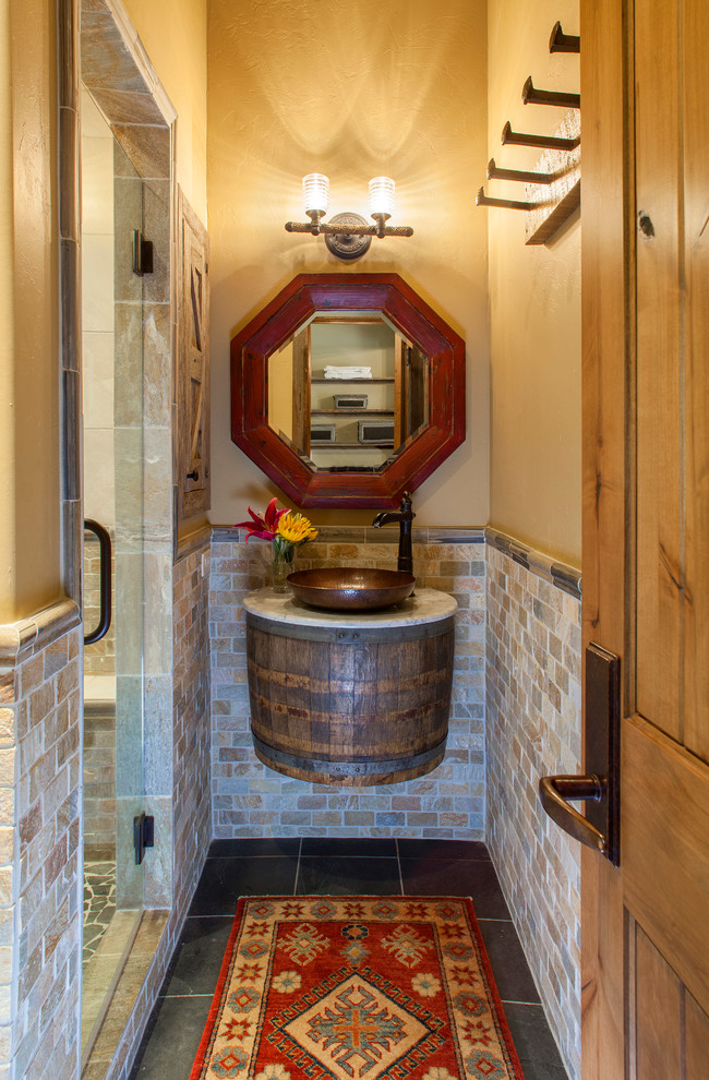 Imagen de cuarto de baño rural con baldosas y/o azulejos beige, paredes beige, lavabo sobreencimera y ducha con puerta con bisagras