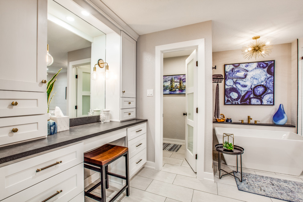 Imagen de cuarto de baño tradicional renovado con armarios estilo shaker, puertas de armario blancas, bañera exenta, paredes grises, suelo blanco y encimeras negras