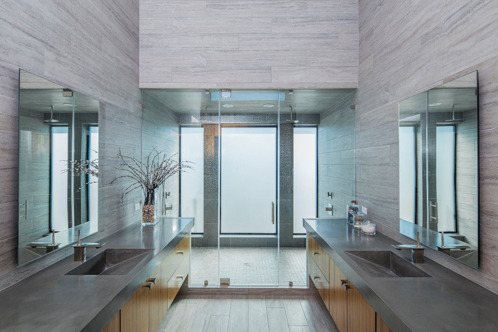 Стильный дизайн: большая главная ванная комната в стиле модернизм с монолитной раковиной, плоскими фасадами, фасадами цвета дерева среднего тона, столешницей из бетона, отдельно стоящей ванной, двойным душем, унитазом-моноблоком, серой плиткой, керамической плиткой, серыми стенами, полом из керамической плитки и душем с распашными дверями - последний тренд