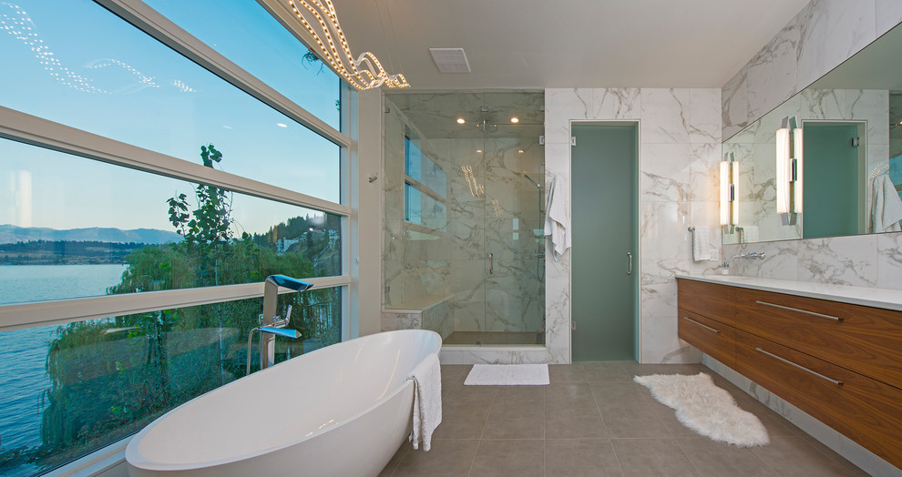 バンクーバーにあるコンテンポラリースタイルのおしゃれなマスターバスルーム (フラットパネル扉のキャビネット、中間色木目調キャビネット、置き型浴槽、アルコーブ型シャワー、白いタイル、グレーの床、開き戸のシャワー) の写真