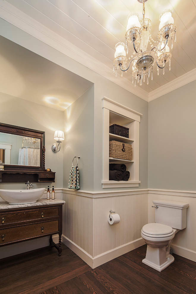 Idee per una stanza da bagno con doccia stile americano di medie dimensioni con lavabo a bacinella, consolle stile comò, ante in legno bruno, top in marmo, WC a due pezzi, pareti blu e parquet scuro