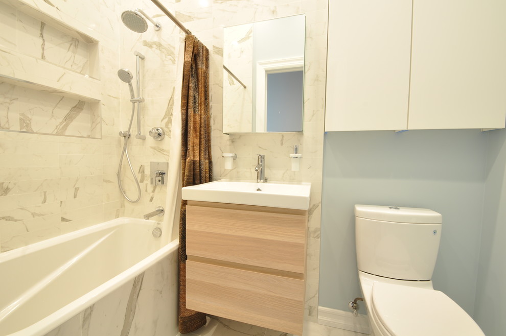 Пример оригинального дизайна: маленькая ванная комната в стиле модернизм с плоскими фасадами, светлыми деревянными фасадами, ванной в нише, душем над ванной, раздельным унитазом, серой плиткой, белой плиткой, каменной плиткой, синими стенами, мраморным полом, монолитной раковиной и столешницей из искусственного камня для на участке и в саду
