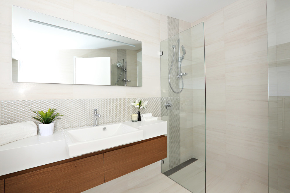 Exempel på ett modernt badrum med dusch, med släta luckor, skåp i mellenmörkt trä, en kantlös dusch och beige kakel