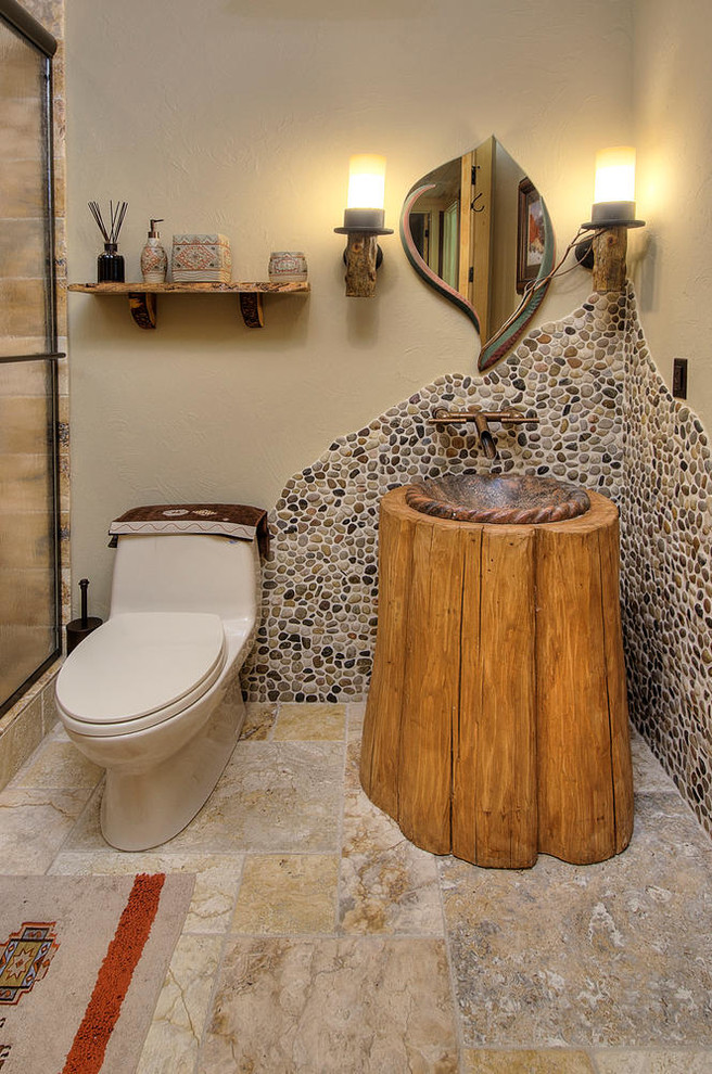 Exempel på ett litet rustikt brun brunt badrum med dusch, med en dusch i en alkov, en toalettstol med hel cisternkåpa, brun kakel, kakel i småsten, beige väggar, ett nedsänkt handfat, träbänkskiva, beiget golv och dusch med skjutdörr