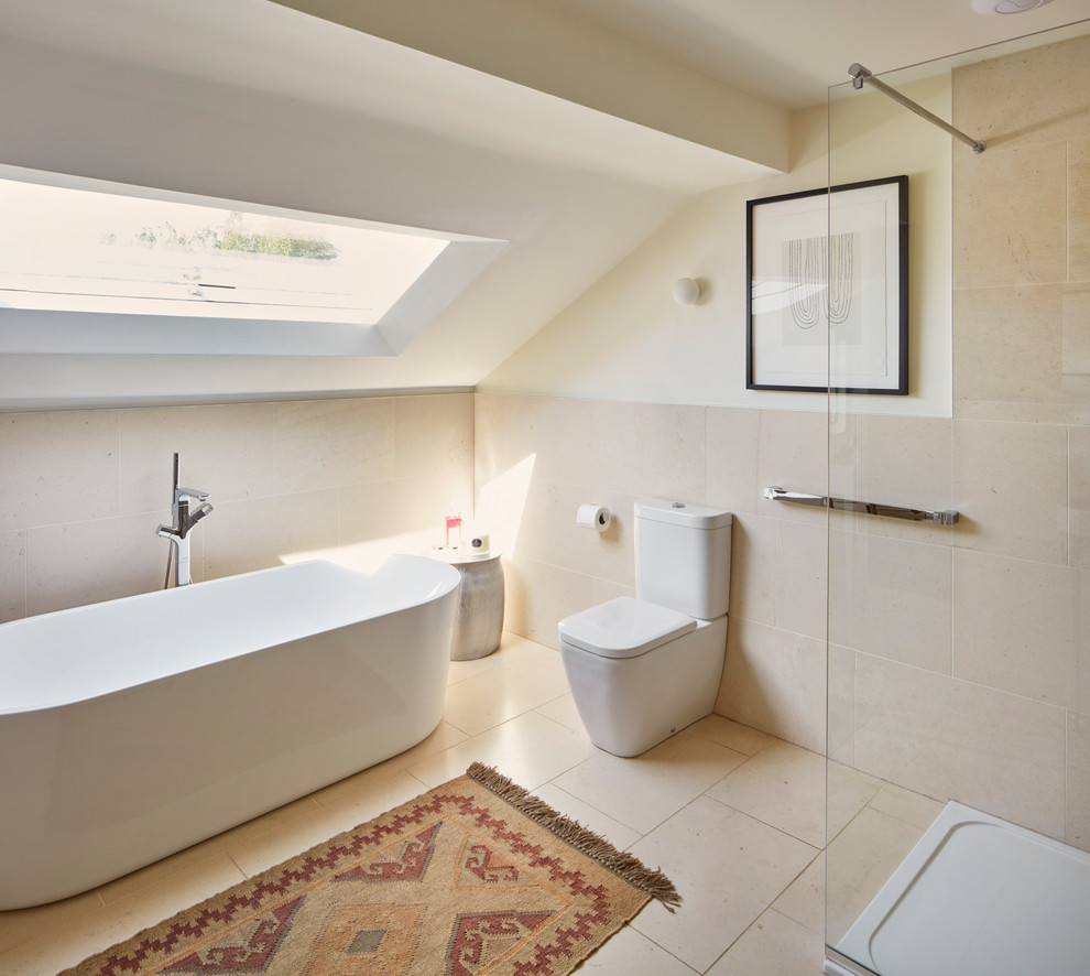 This is an example of a medium sized contemporary bathroom in Berkshire with a freestanding bath, a walk-in shower, a one-piece toilet, beige walls, beige floors and an open shower.