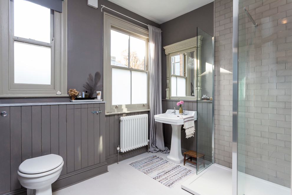 Bild på ett minimalistiskt badrum, med ett piedestal handfat, en hörndusch, grå kakel, tunnelbanekakel och grå väggar
