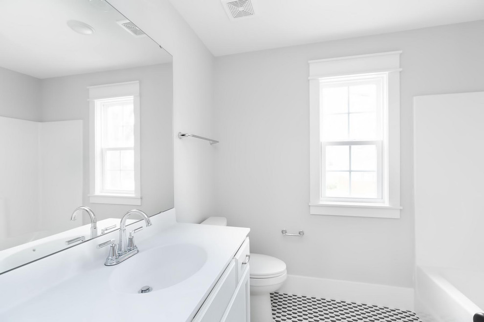 Mid-sized elegant kids' ceramic tile, multicolored floor and single-sink bathroom photo in Raleigh with recessed-panel cabinets, white cabinets, a two-piece toilet, gray walls, an integrated sink, marble countertops, white countertops and a built-in vanity