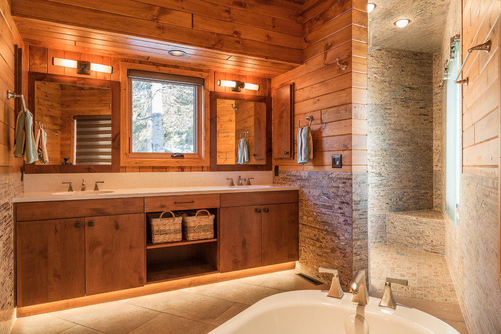 Cette photo montre une salle de bain principale montagne en bois brun avec un placard à porte plane, un plan de toilette en quartz modifié, une douche d'angle, un carrelage de pierre et un sol en carrelage de porcelaine.