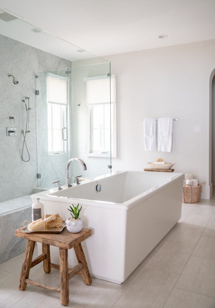 Diseño de cuarto de baño costero con bañera exenta, baldosas y/o azulejos grises, paredes blancas y suelo gris