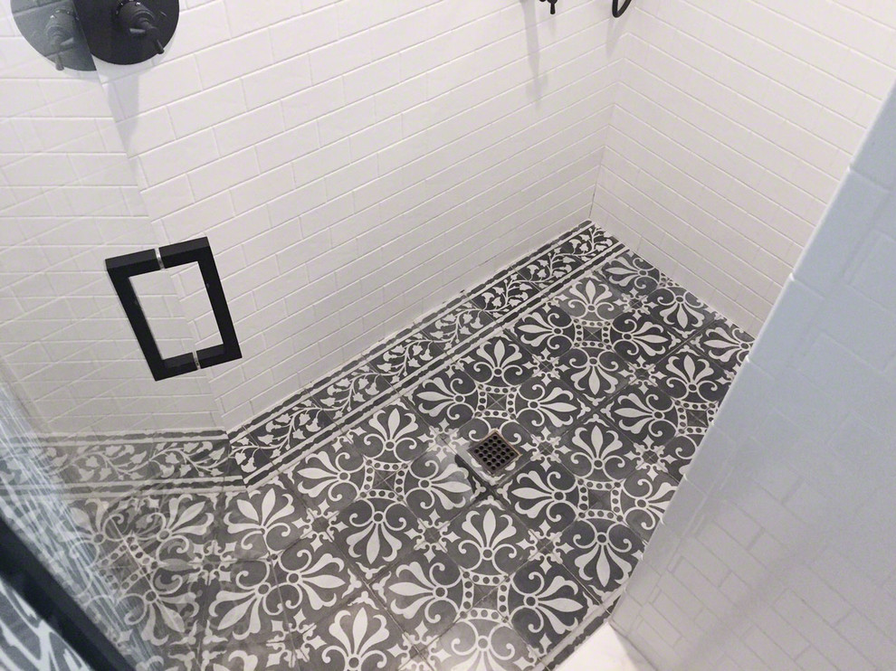 Immagine di una stanza da bagno mediterranea con doccia aperta e piastrelle nere