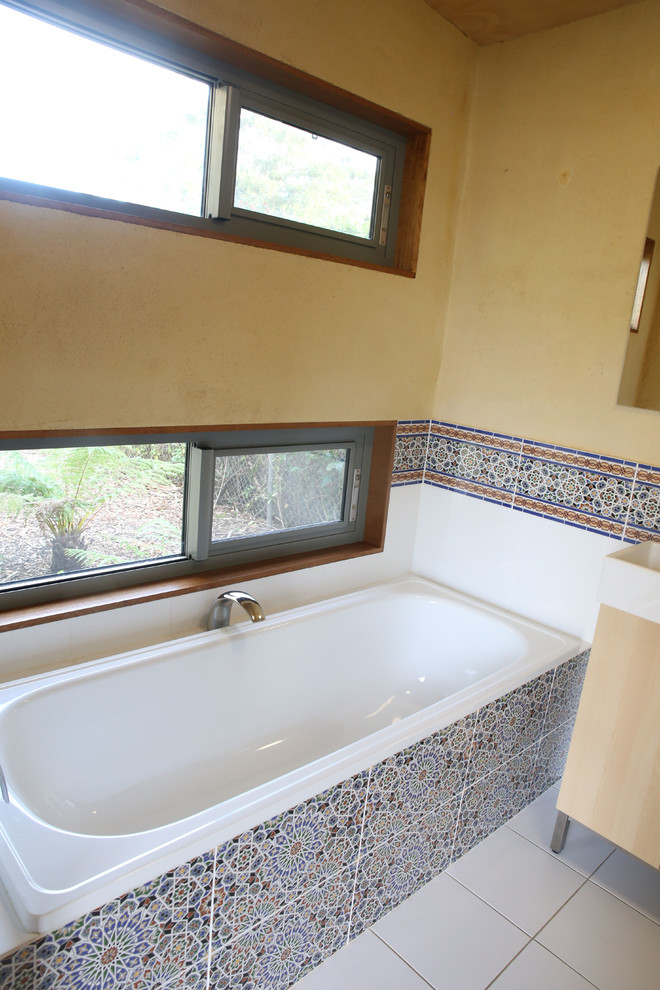 Aménagement d'une petite salle de bain méditerranéenne en bois clair avec une douche d'angle, des carreaux de céramique, un mur jaune et un sol en carrelage de céramique.