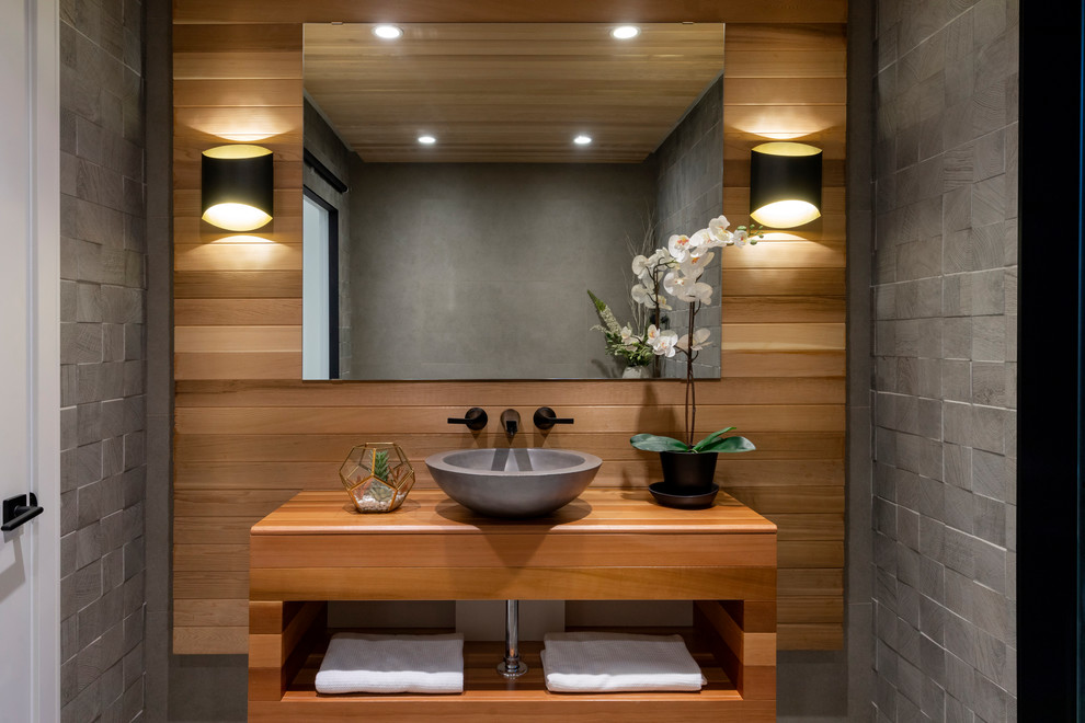 Idées déco pour une salle de bain contemporaine en bois brun avec un carrelage gris, une vasque, un plan de toilette en bois et un plan de toilette marron.