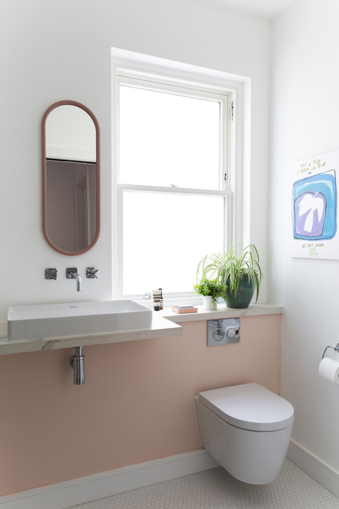 Стильный дизайн: маленькая ванная комната в современном стиле с инсталляцией, розовыми стенами, полом из керамогранита, душевой кабиной, раковиной с несколькими смесителями, мраморной столешницей, белым полом, белой столешницей, нишей, тумбой под одну раковину и подвесной тумбой для на участке и в саду - последний тренд