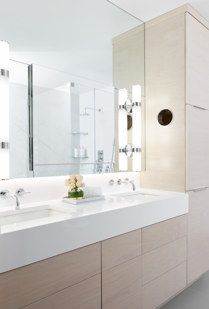 Photo of a medium sized contemporary ensuite bathroom in New York with flat-panel cabinets, light wood cabinets, white tiles, marble tiles, porcelain flooring, a submerged sink, engineered stone worktops, grey floors and white worktops.