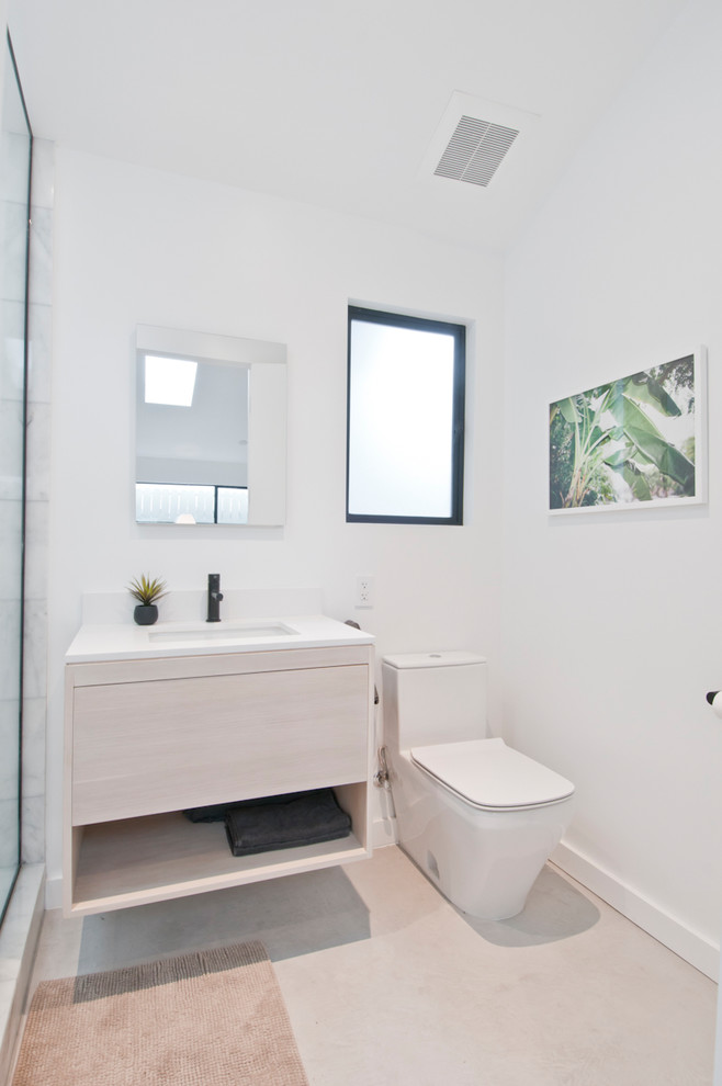 Идея дизайна: маленькая главная ванная комната в стиле модернизм с плоскими фасадами, светлыми деревянными фасадами, открытым душем, унитазом-моноблоком, белой плиткой, мраморной плиткой, белыми стенами, бетонным полом, накладной раковиной, столешницей из искусственного кварца, серым полом, открытым душем и белой столешницей для на участке и в саду