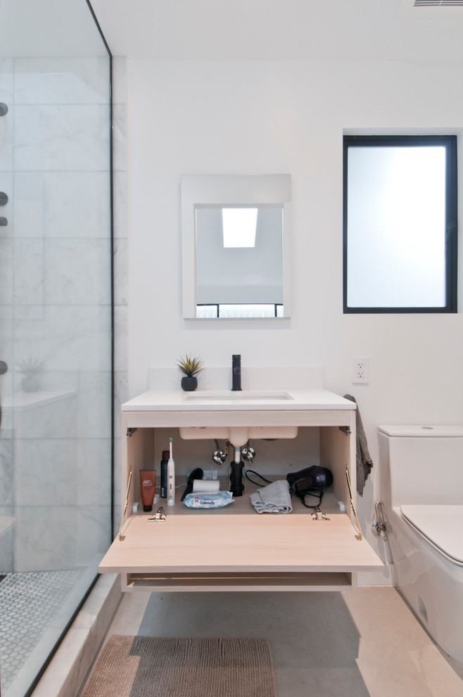 Свежая идея для дизайна: маленькая главная ванная комната в стиле модернизм с плоскими фасадами, светлыми деревянными фасадами, открытым душем, унитазом-моноблоком, белой плиткой, мраморной плиткой, белыми стенами, бетонным полом, накладной раковиной, столешницей из искусственного кварца, серым полом, открытым душем и белой столешницей для на участке и в саду - отличное фото интерьера