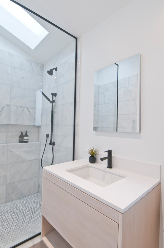 Design ideas for a small modern ensuite bathroom in Los Angeles with flat-panel cabinets, light wood cabinets, a walk-in shower, a one-piece toilet, white tiles, marble tiles, white walls, concrete flooring, a built-in sink, engineered stone worktops, grey floors, an open shower and white worktops.
