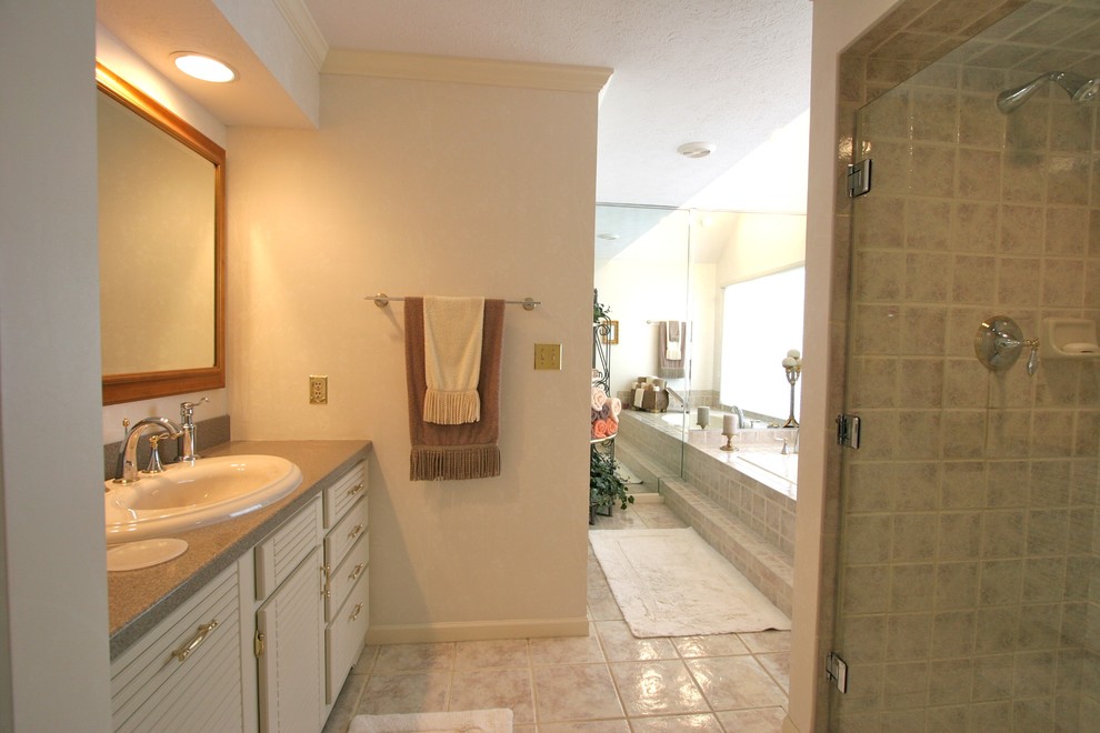 Cette image montre une salle de bain traditionnelle de taille moyenne avec des portes de placard blanches, une baignoire posée, un sol en carrelage de céramique et un lavabo posé.