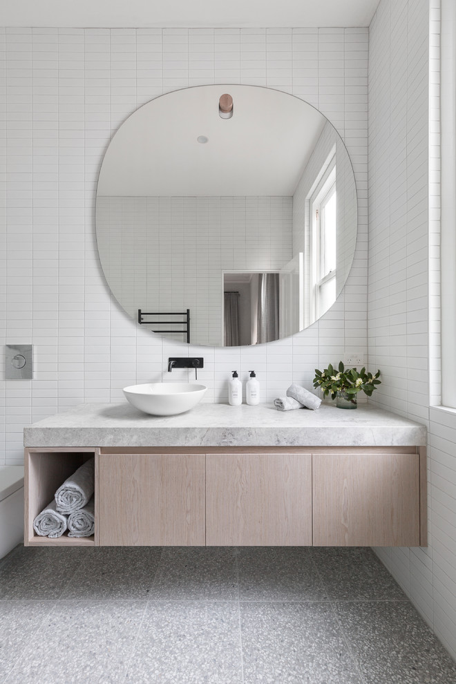 メルボルンにあるコンテンポラリースタイルのおしゃれな浴室 (フラットパネル扉のキャビネット、ベージュのキャビネット、白いタイル、白い壁、木製洗面台、グレーの床、グレーの洗面カウンター) の写真