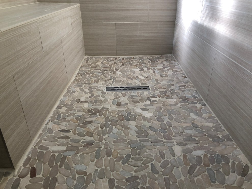 На фото: большая главная ванная комната в стиле модернизм с душем без бортиков, серой плиткой, керамической плиткой, полом из галечной плитки и врезной раковиной