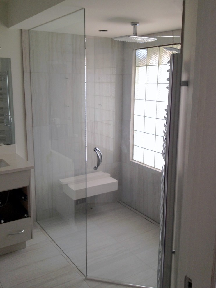Geräumiges Modernes Duschbad mit Unterbauwaschbecken, grauen Schränken, Quarzit-Waschtisch, bodengleicher Dusche, grauen Fliesen und Steinfliesen in Vancouver
