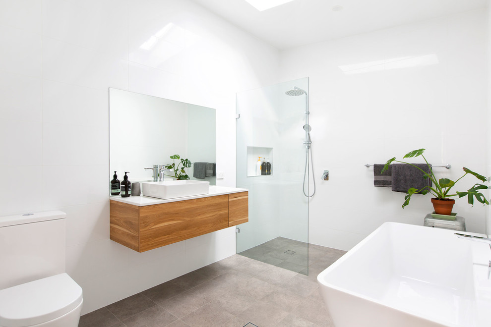 Inredning av ett modernt mellanstort badrum, med vita skåp, en öppen dusch, vit kakel, cementgolv och med dusch som är öppen