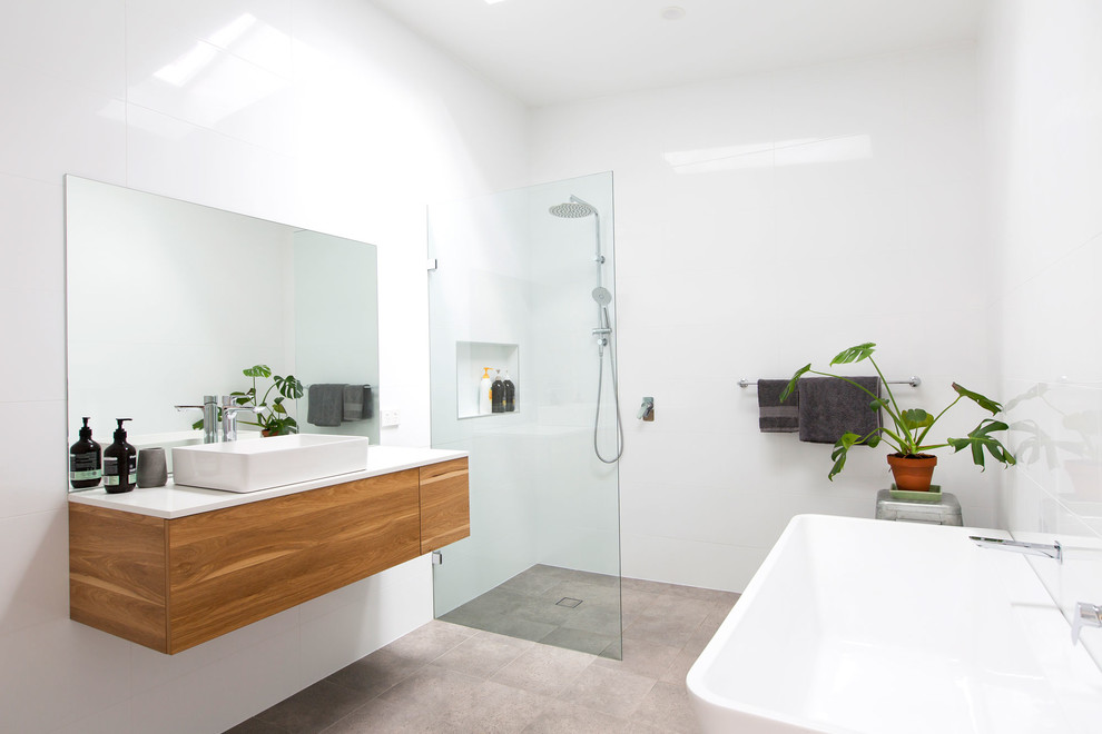 This is an example of a medium sized contemporary bathroom in Newcastle - Maitland with white cabinets, a walk-in shower, white tiles, cement flooring and an open shower.