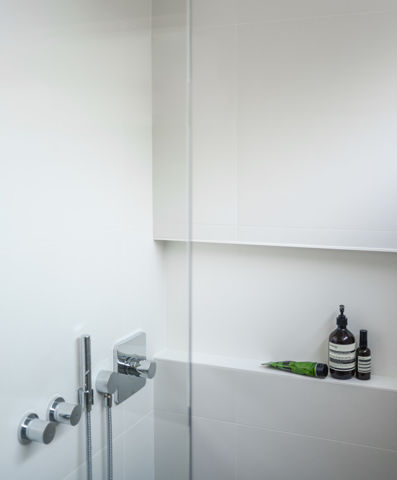 This is an example of a medium sized retro ensuite bathroom in Vancouver with flat-panel cabinets, medium wood cabinets, engineered stone worktops, a freestanding bath, a two-piece toilet, white tiles, porcelain tiles, white walls, porcelain flooring and a submerged sink.