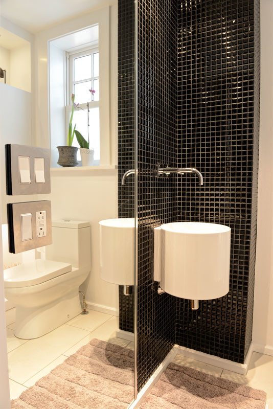 Esempio di una stanza da bagno con doccia design di medie dimensioni con WC monopezzo, piastrelle nere, piastrelle a mosaico, pareti bianche e pavimento con piastrelle in ceramica