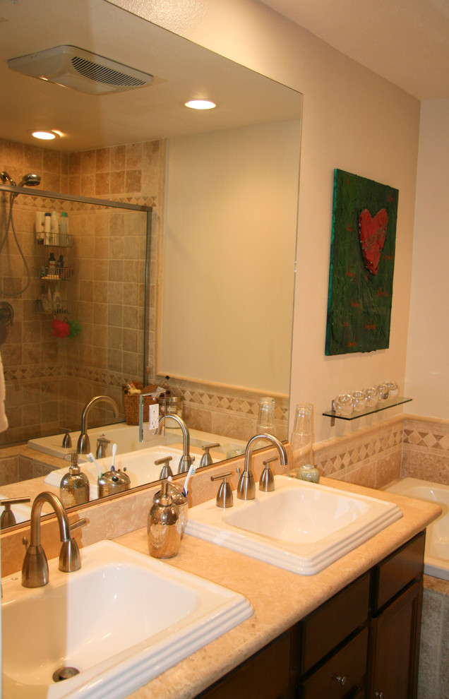 Example of a mid-sized eclectic master beige tile and stone tile travertine floor bathroom design in Los Angeles with a drop-in sink, flat-panel cabinets, dark wood cabinets, limestone countertops, a two-piece toilet and beige walls