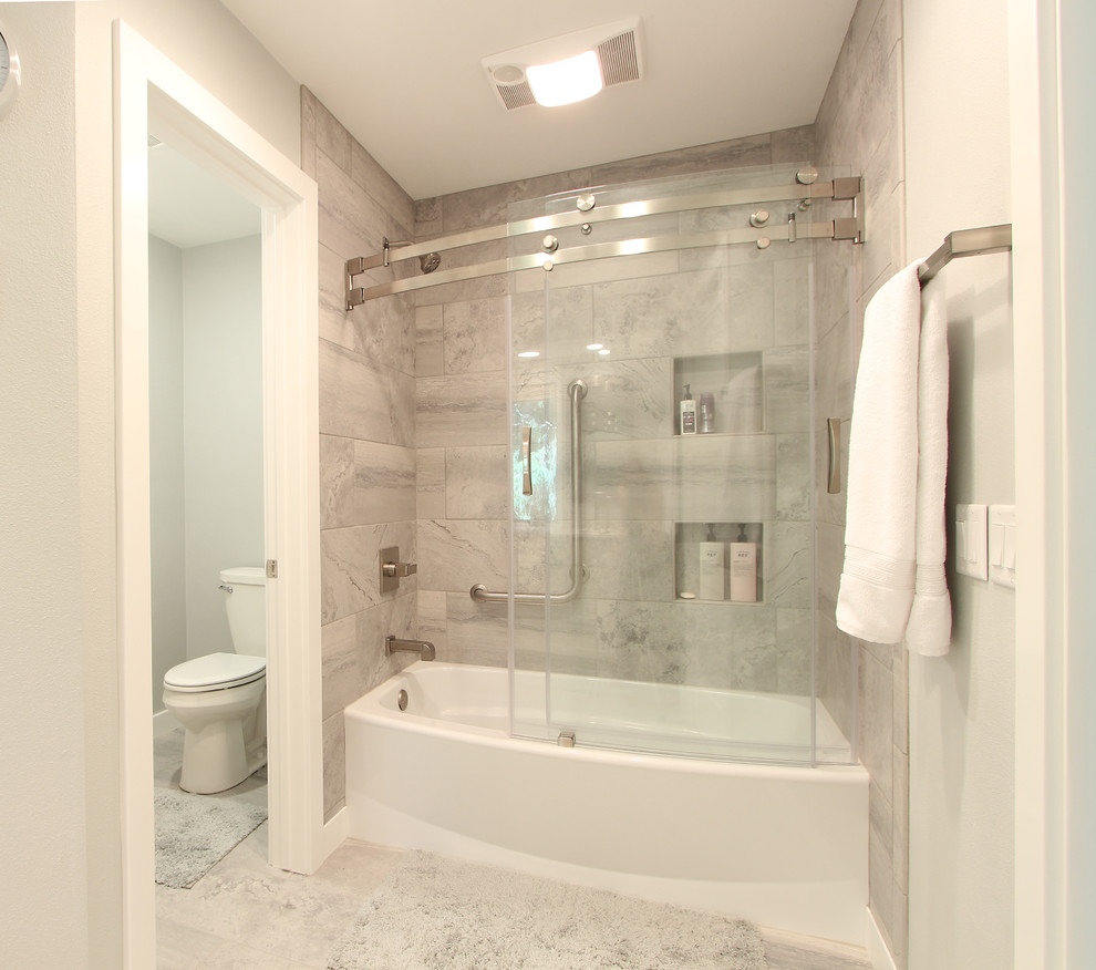 На фото: главная ванная комната среднего размера в стиле неоклассика (современная классика) с фасадами в стиле шейкер, белыми фасадами, ванной в нише, раздельным унитазом, серой плиткой, мраморной плиткой, серыми стенами, мраморным полом, врезной раковиной, столешницей из искусственного кварца, белым полом, душем с раздвижными дверями и душем над ванной с