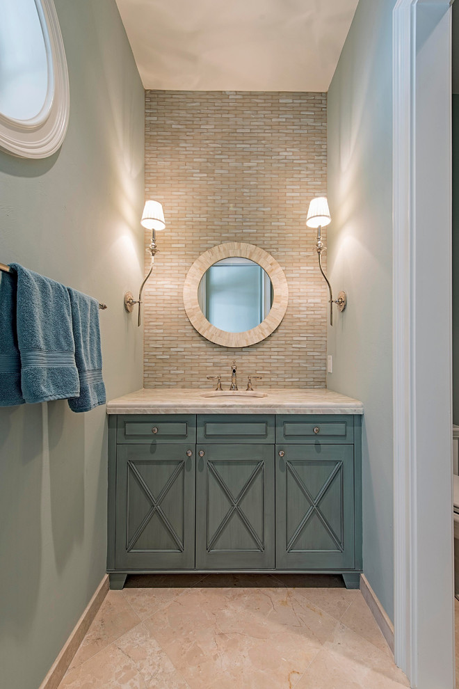 Cette image montre une petite salle de bain traditionnelle avec un placard en trompe-l'oeil, WC à poser, un carrelage multicolore, un carrelage de pierre, un lavabo encastré, des portes de placard turquoises, un mur bleu, un sol en marbre et un plan de toilette en marbre.