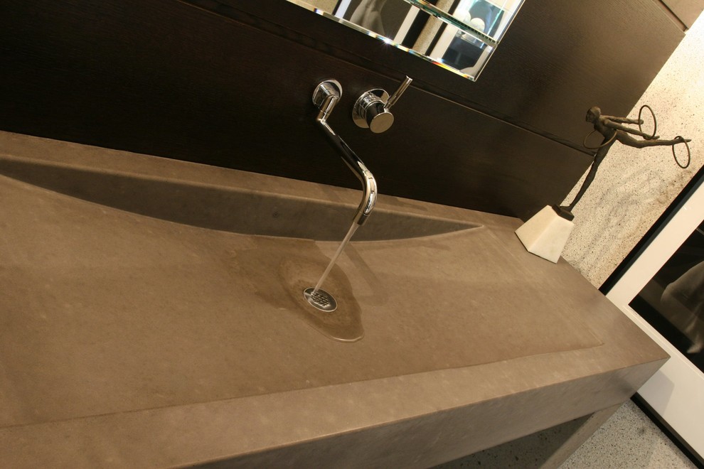 Immagine di una piccola stanza da bagno design con WC monopezzo, piastrelle marroni, piastrelle in gres porcellanato, pareti multicolore, pavimento in gres porcellanato, lavabo integrato e top in cemento