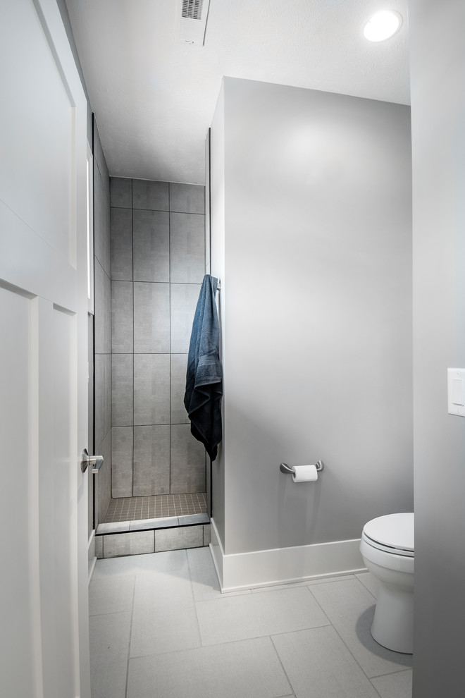 Foto på ett mellanstort vintage grå badrum med dusch, med en dusch i en alkov, en toalettstol med hel cisternkåpa, grå väggar, klinkergolv i keramik, släta luckor, vita skåp, ett undermonterad handfat, bänkskiva i kvarts, grått golv och med dusch som är öppen