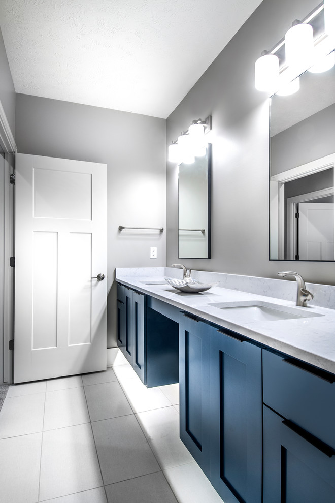 Пример оригинального дизайна: ванная комната среднего размера в стиле неоклассика (современная классика) с фасадами в стиле шейкер, синими фасадами, серой плиткой, серыми стенами, полом из керамической плитки, белой столешницей, душевой кабиной, врезной раковиной, столешницей из кварцита и серым полом