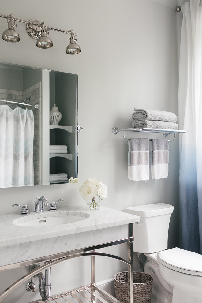 Bild på ett mellanstort vintage badrum med dusch, med öppna hyllor, en dusch/badkar-kombination, en toalettstol med separat cisternkåpa, vit kakel, marmorkakel, grå väggar, ett undermonterad handfat, marmorbänkskiva och dusch med duschdraperi