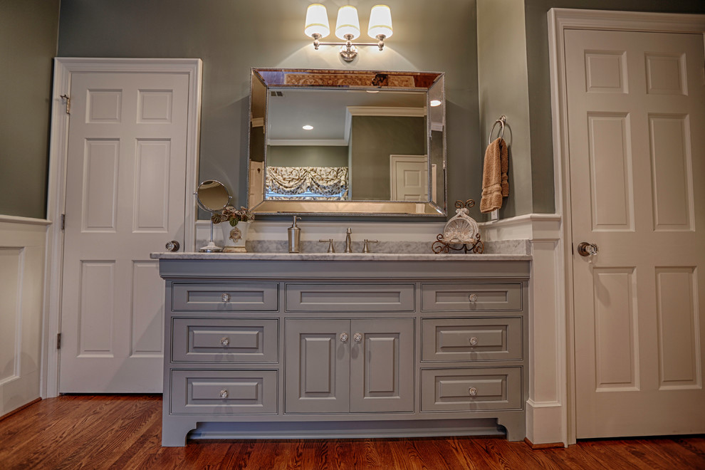 Freestanding bathtub - mid-sized traditional master medium tone wood floor freestanding bathtub idea in Birmingham with beaded inset cabinets, gray cabinets, quartzite countertops and gray walls