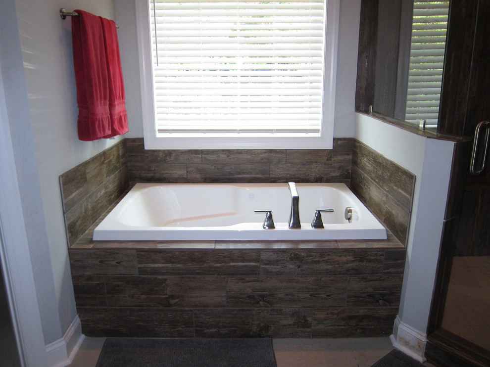Cette image montre une salle d'eau traditionnelle de taille moyenne avec une baignoire posée, une douche d'angle, un carrelage marron, des carreaux de porcelaine, un mur gris, un sol en carrelage de porcelaine, un sol beige et une cabine de douche à porte battante.