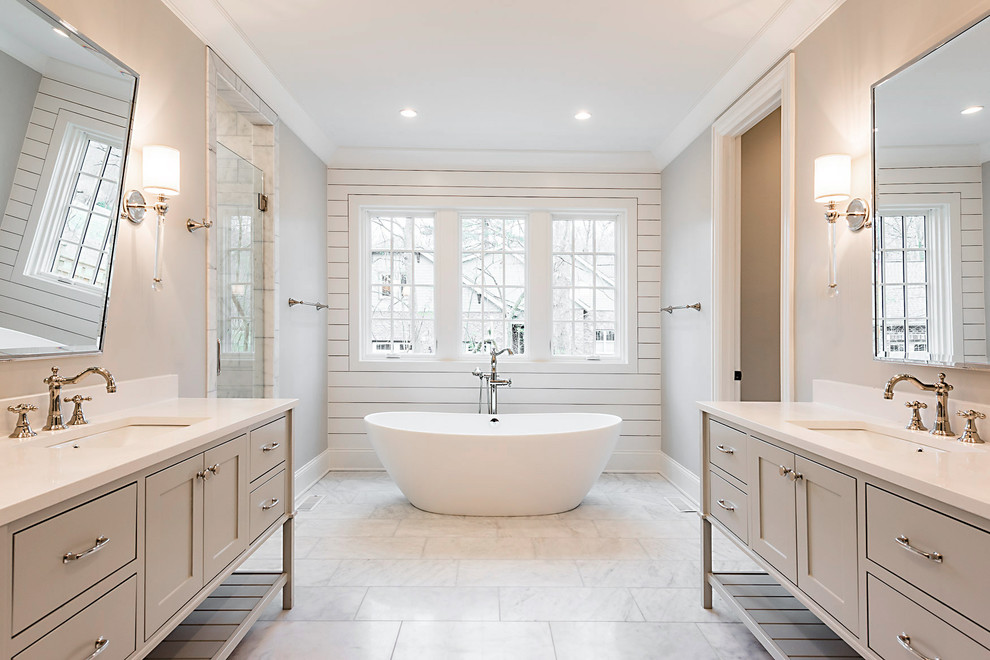 Foto på ett stort lantligt en-suite badrum, med släta luckor, grå skåp, ett fristående badkar, grå väggar, marmorgolv, ett undermonterad handfat, bänkskiva i akrylsten och vitt golv