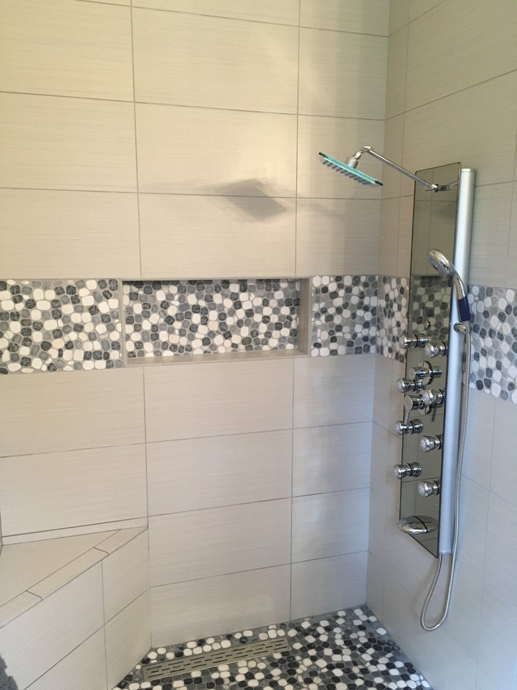 На фото: ванная комната среднего размера в стиле неоклассика (современная классика) с угловым душем, бежевой плиткой, керамогранитной плиткой, полом из галечной плитки, разноцветным полом и душем с распашными дверями