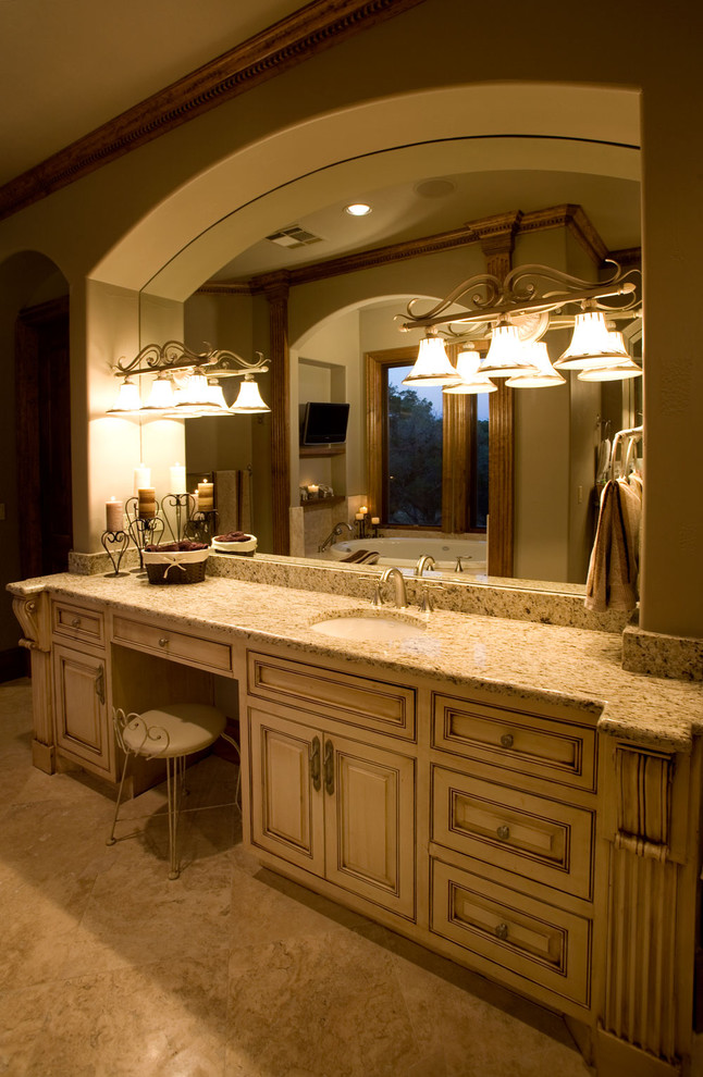 Exempel på ett mellanstort klassiskt en-suite badrum, med ett undermonterad handfat, luckor med profilerade fronter, beige skåp, granitbänkskiva, ett badkar i en alkov, bruna väggar och travertin golv