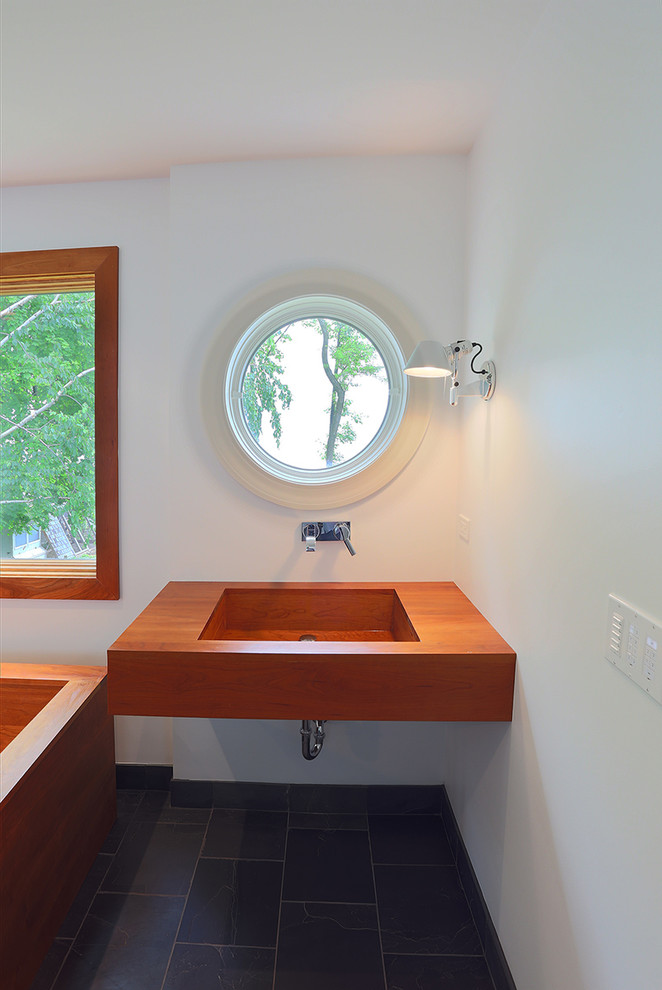 Свежая идея для дизайна: большая главная ванная комната в стиле модернизм с японской ванной, открытым душем, инсталляцией, белыми стенами, полом из известняка, подвесной раковиной, столешницей из дерева, серым полом и душем с распашными дверями - отличное фото интерьера